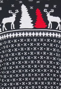 Dunkelblauer Pullover mit weißen und roten Weihnachtsmotiven, einschließlich Rentieren und Bäumen, im strukturierten Strickdesign.