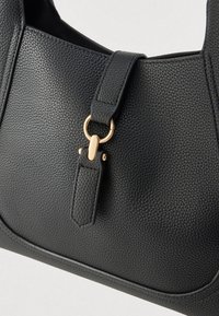 Svart skinnveske med kornet tekstur, utstyrt med en gullfarget lås og en kort, tydelig skulderstropp.