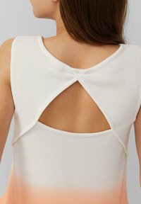 Ärmelloses, geripptes Top in Weiß mit einem Ombre-Effekt, der zu Pfirsich übergeht. Mit einem Schlüsselloch-Ausschnitt auf der Rückseite und glatter Textur.