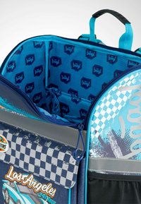 Zaino blu con motivo a scacchi e design grafico. Materiale morbido con scomparti con zip e una fodera interna texturizzata.