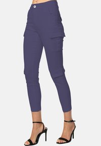 Paarse cargobroek met een slim fit, met zijzakken, een ritssluiting en een korte lengte, gecombineerd met zwarte sandalen met straps.