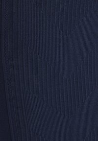 Close-up af mørk marineblåt stof med lodret ribbet og struktureret strikkemønster.