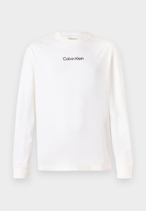 Weißes langärmeliges Crew-Neck-Shirt mit dem in Schwarz auf der Brust zentrierten "Calvin Klein"-Logo.