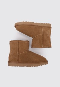Bottes chelsea en daim marron avec un bout rond, une texture douce, une hauteur basse aux chevilles et une semelle en caoutchouc. Détails de couture le long des coutures.