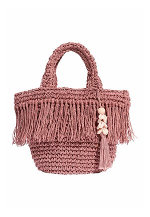 Sac à main en crochet rose avec des détails en franges et un pompon orné de petites coquilles beiges suspendu à une anse.