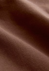 Brauner Textilstoff mit einer glatten Oberfläche und feinem Rippmuster, das einen reichen, warmen Farbton und ein weiches Erscheinungsbild zeigt.