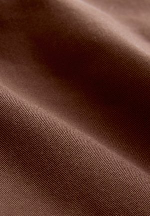 Ruskotettua kangasta, jossa on sileä pinta ja hienovarainen raidoituskuvio, esittelee rikkaita, lämpimiä sävyjä ja pehmeää ulkonäköä.