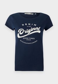 Marineblå bomull T-skjorte med korte ermer, rund hals og hvit trykt tekst "DENIM Original" og "GOOD TIMES AHEAD."