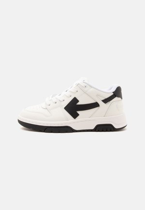 Basket basse blanche avec un motif de flèche noire sur le côté, lacets blancs, col rembourré et semelle en caoutchouc noire et blanche.