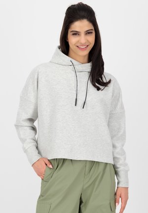 Helle graue, kurz geschnittene Kapuzenjacke mit Kordelzug, lockerer Passform und strukturiertem Stoff. Kombiniert mit olivgrünen Cargo-Hosen.