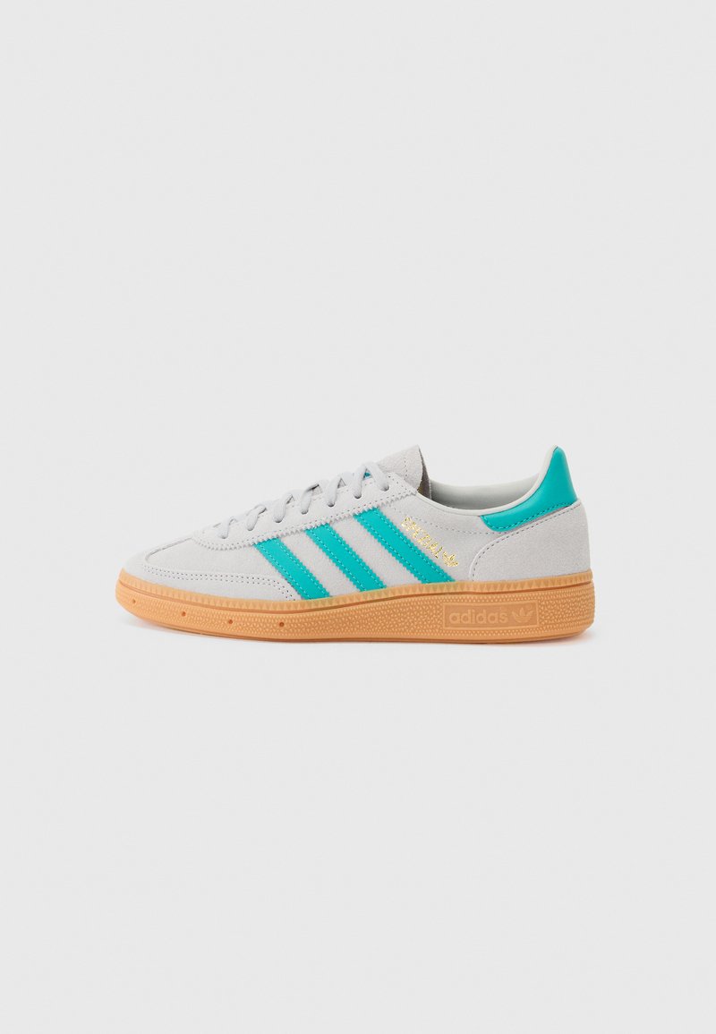 Grå ruskinds sneakers med teal tre striber, guld accenter og gummisåler. Klassisk low-top design med tekstureret tå og polstret krave.