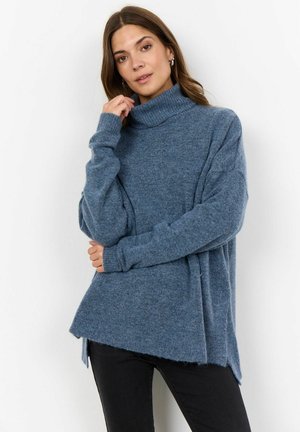 Light blue turtleneck sweater made of soft knit material, featuring a relaxed fit, dropped shoulders, and side slits for added movement.