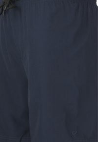 Tummansiniset uimapuvut, jotka on valmistettu kevyestä kankaasta. Niissä on joustava vyötärönyöri, huomaamaton brändäys ja sileä pinta.