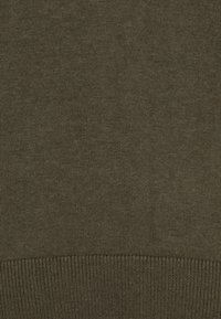 Olivgrüner Strickstoff mit enger Webart und geripptem Saumdetail am unteren Rand.