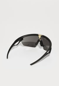 Schwarze Sonnenbrille mit einem Wickeldesign, dunkel getönten Gläsern und goldenen Akzenten an der Brücke. Strukturierten Bügeln mit Belüftungsmerkmalen.