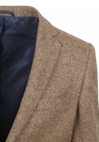 Bruine herringbone tweed blazer met een notch-kraag en een enkele zak. Gevoerd met marineblauwe stof en voorzien van een gestructureerd oppervlak.