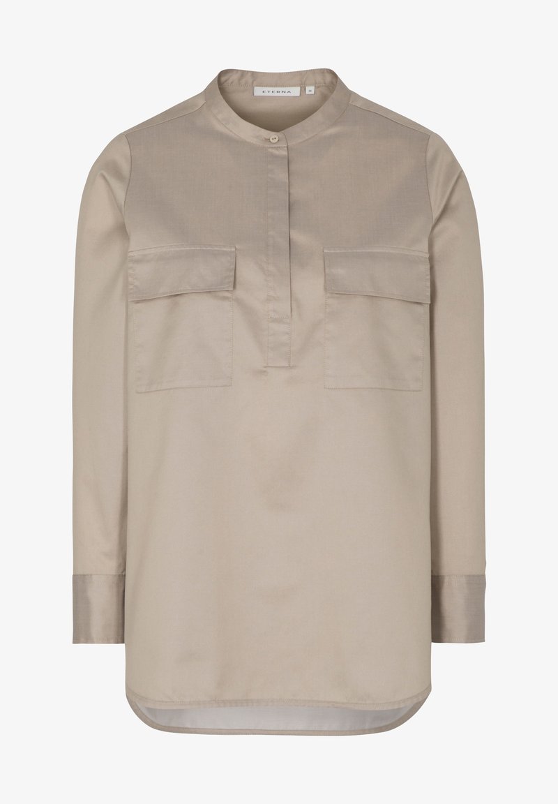 Chemise beige clair à manches longues avec col mao, deux poches avant à rabat, patte de boutonnage et ourlet arrondi.