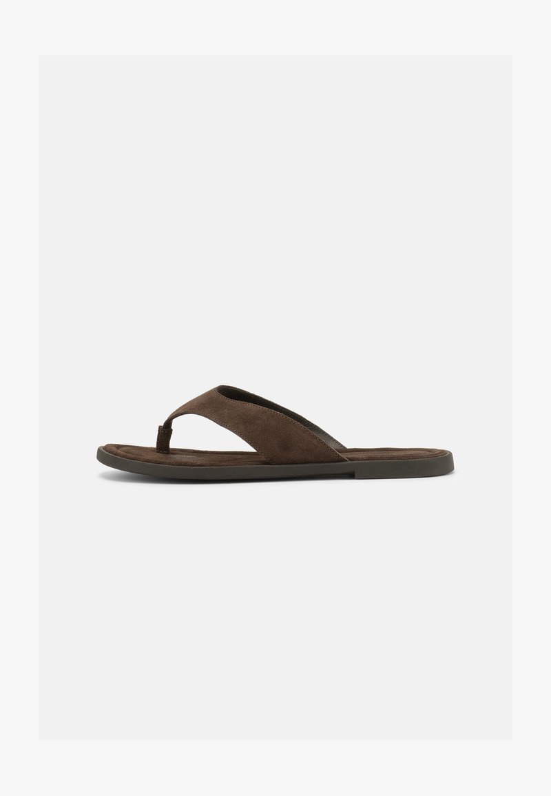 Καφέ σουέντ σαγιονάρα με φαρδιά λουράκι και διαχωριστικό δάχτυλο πάνω σε επίπεδη, σκούρα σόλα σε απλό ανοιχτό φόντο.