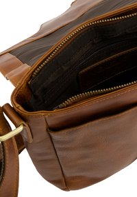 Brun læder crossbody taske med en lynlåslukket hovedrum, indvendige lommer og en struktureret overflade. Justerbar rem og metalbeslag.