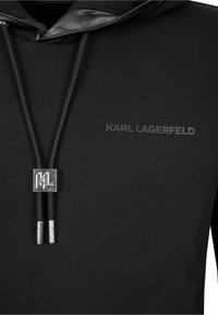 Felpa nera con cappuccio e logo nero testurizzato "KARL LAGERFELD" sul petto, caratterizzata da un laccetto lucido nero con dettagli in metallo.