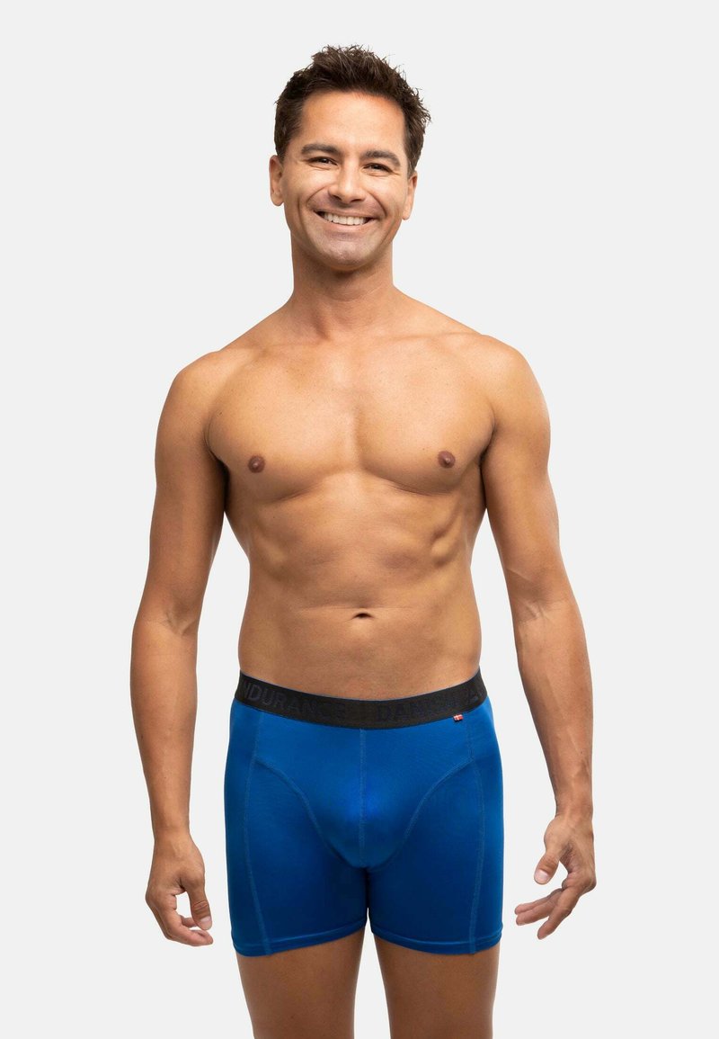 Pánské modré boxerky s černým elastickým pasem, na kterém je nápis "ENDURANCE." Hladká tkanina a přiléhavý střih s podpůrným sáčkem.