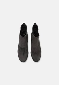 Mustat mokkanahkaiset nilkkurit, joissa on sileä pinta, vetoketjusuljenta ja vetotappi. Muotoiltu pyöristetyllä kärjellä ja joustavalla kumipohjalla.