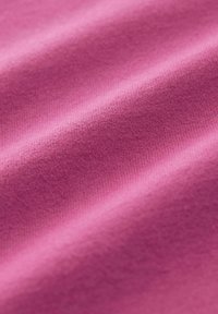 Tissu d'un rose vif, présentant une texture lisse et extensible avec de fines mailles et un léger éclat sur toute la surface.