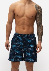 Zwemshorts van lichtgewicht stof, navy met tropische patronen van palmbomen en bergen, met een elastische tailleband en trekkoord.
