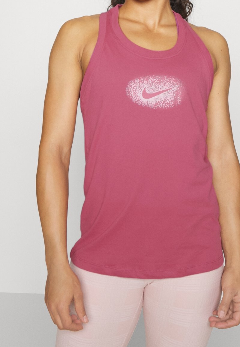 Top atlético rosa con escote redondeado, que presenta un logo de Nike blanco moteado en el centro. Tejido suave y ligero.