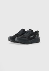 Juodo poros Skechers bėgimo batų su tinklinėmis šoninėmis dalimis, su raišteliais ir paminkštintu Ultra Light padu ant paprasto balto fono.