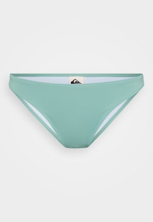 Mentazöld bikini alsó, sima textúrával, fehér oldalsó kivágásokkal és márkajelzéssel a hátulján. Kényelemre és illeszkedésre tervezve.