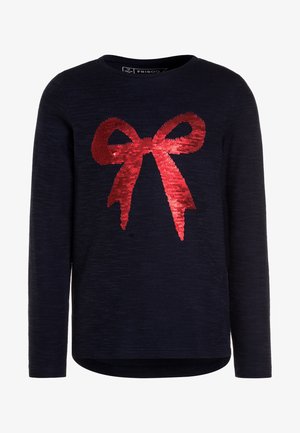 Chemise bleu marine à manches longues avec un grand nœud en sequins rouges sur le devant et un col rond.