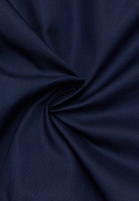 Marineblauwe stof met een gladde textuur, voorzien van een geweven patroon en een lichte glans, in een spiraalvorm gerangschikt om de val en flexibiliteit te benadrukken.