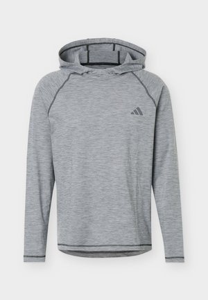 Gaiši pelēks sporta kapučveida džemperis ar melnām šuvēm un mazu tumši pelēku Adidas logotipu kreisajā krūtīs.