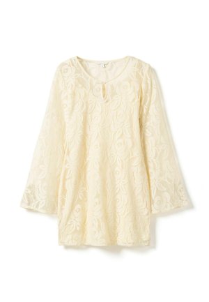 Kremowa bluzka z długim rękawem z koronki z kwiatowym wzorem oraz małym wycięciem w kształcie klucza przy okrągłym dekolcie.