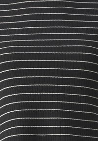 Černá žebrovaná látka s tenkými horizontálními bílými pruhy rovnoměrně rozmístěnými po celé ploše.