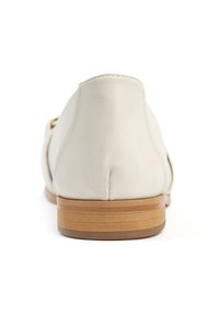 Zapato de cuero blanco con tacón redondeado, textura suave y suela parecida a la madera. Diseño minimalista sin herrajes o acentos visibles.