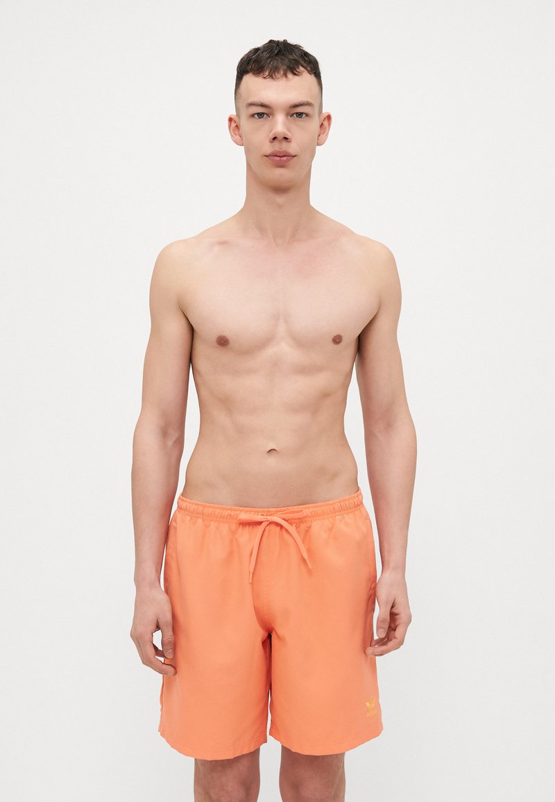 Herresvømmeshorts i lys orange. Fremstillet af letvægtsstof, med en elastisk talje og snøre samt en lille logodetalje.