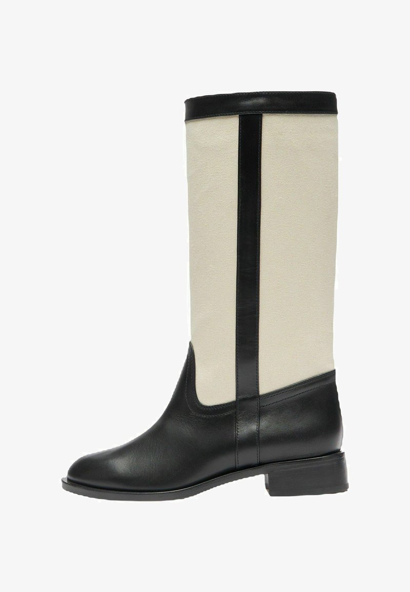 Kozaki do kolan z czarną skórzaną cholewką i wykończeniem, beżowym materiałowym trzonem, niskim obcasem i okrągłym noskiem, pokazane z boku na białym tle.