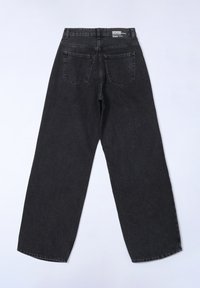 Zwarte denim jeans met een losse pasvorm, vijf zakken, riemlussen en een vervaagde textuur. Beschikt over een label op de tailleband aan de achterkant.