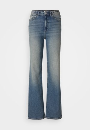 Jean flare bleu en denim, avec un délavage fade, taille haute, design à cinq poches et détails de couture visibles.
