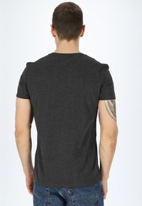 Maglietta grigia a maniche corte con colletto rotondo, realizzata in un tessuto morbido. Il retro presenta una texture liscia e un design aderente.