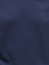 Ναυτικό μπλε ύφασμα με μικρή ασημένια καρδιά κεντημένη στο πάνω δεξί μέρος.