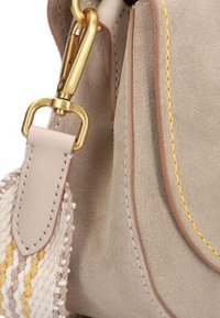 Beige suède handtas met een leren strap, gouden hardware en geweven accenten in geel en wit. Voorzien van contrasterende stikseldetails.