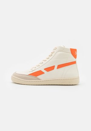 Baskets montantes blanches avec embout beige, accents latéraux orange et languette de talon orange, présentées en profil sur fond blanc.