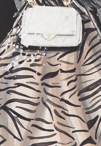 Witte gequiltte handtas met gouden hardware, gecombineerd met een doorschijnende jurk met een zwart zebra-streep patroon op een crème achtergrond.