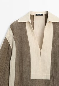 Overhemd met lange mouwen met brede verticale strepen in beige en bruin, met een diepe V-hals en een brede kraag.