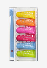 Brosse à dents avec un manche bleu à côté de six tubes de dentifrice colorés : jaune, orange, rose, rouge, vert et bleu, chacun étiqueté avec des noms uniques.
