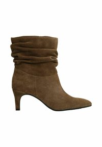 Bruine suède slouchy enkellaars met een puntige teen en een taps toelopende hak van gemiddelde hoogte, zijwaarts weergegeven tegen een witte achtergrond.