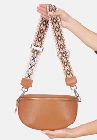 Braune Leder-Crossbody-Tasche mit strukturierter Oberfläche, ausgestattet mit einem gemusterten Tragegurt in Creme-, Braun- und Schwarztönen. Reißverschluss oben.